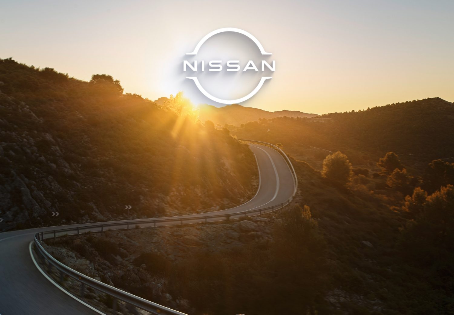 Nissan Logo über Bergstraße im Sonnenuntergang