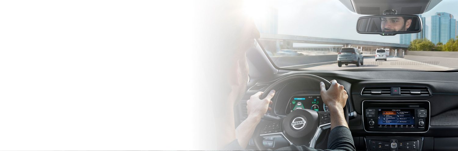 Hombre al volante de un Nissan LEAF con Nissan Intelligent Mobility