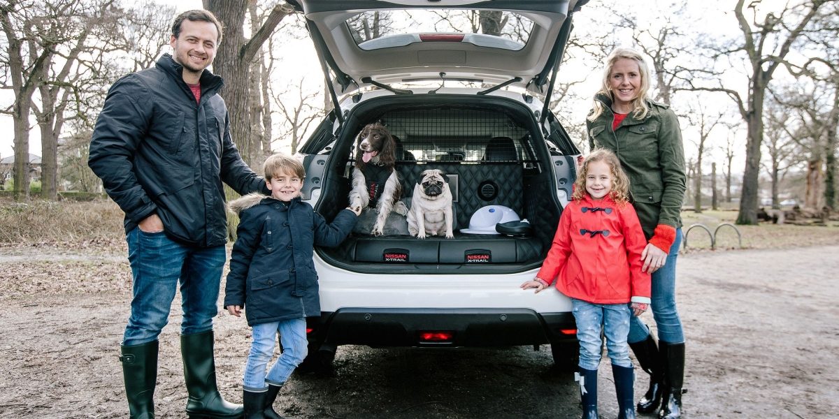 Family with children and dogs infront of X-Trail
