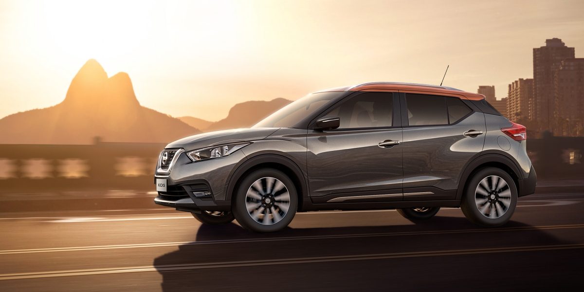 Նարնջագույն և մոխրագույն Nissan Kicks-ի արտաքին տեսքը մերձափնյա ճանապարհին