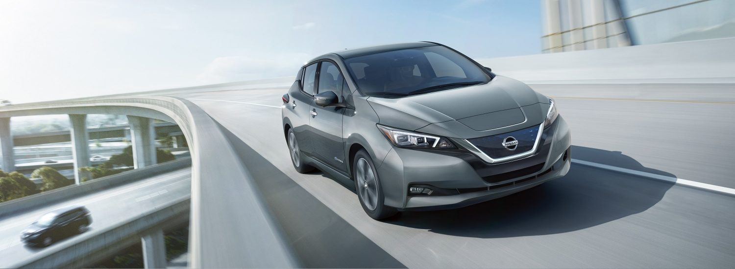 Nissan LEAF shown from the front driving on a highway overpass