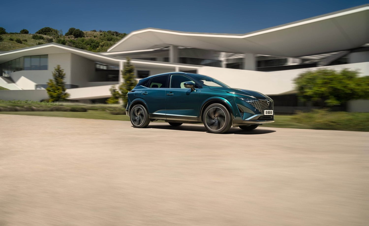 Nissan Qashqai e-POWER sõidupilt taustal sild – hübriidmaastur.
