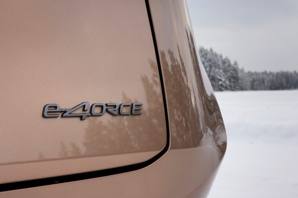 Nissan ARIYA som kjører i snø med e-4ORCE firehjulstrekk-emblem på bagasjeromsluken