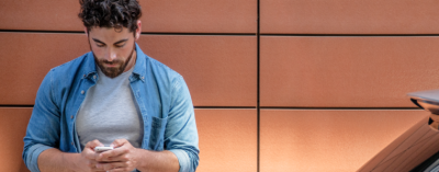 Een hand die een smartphone vasthoudt, waarop de NissanConnect Services app te zien is.
