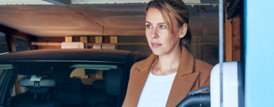 Een vrouw laadt haar auto op met een thuislader.