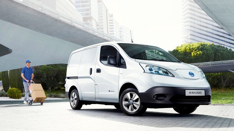 Jaunais Nissan e-NV200 – priekšējās 3/4 un vīrs, kurš dodas pie automobiļa ar rokas ratiņiem
