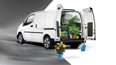 Vue 3/4 arrière du Nouveau Nissan e-NV200 avec fleurs dans l’espace de chargement