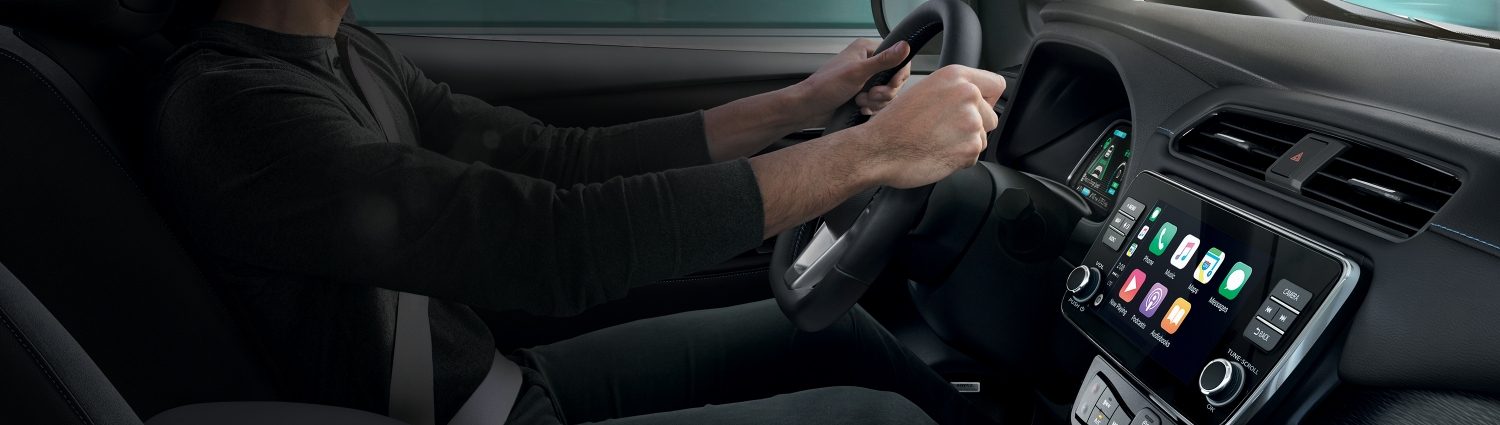 Nissan LEAFin sisätilat, joissa näkyy mies ajamassa ja keskikonsoli