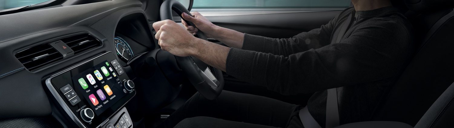 Nissan LEAF interior showing man driving and centre console