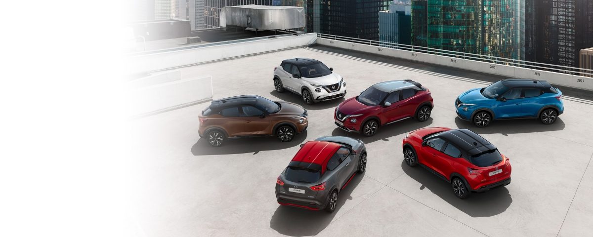 Nissan JUKE's in twee lakkleuren geparkeerd op de bovenverdieping van een parkeergarage