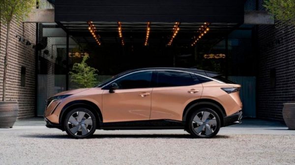 Außenaufnahme des Nissan ARIYA im Profil, vor einem Gebäude