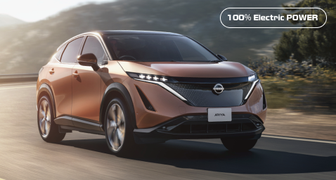 Der atemberaubende neue Nissan ARIYA fährt auf einer Bergstraße.