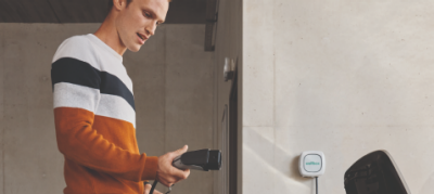 Ein Mann schließt sein Fahrzeug an eine Wallbox an.