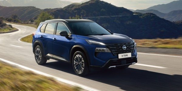 Der Nissan X-Trail fahrend auf einer Landstraße.
