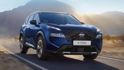 Der Nissan X-Trail fährt auf einer Straße.