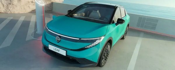Ръка включва зарядно устройство в електрически автомобил.