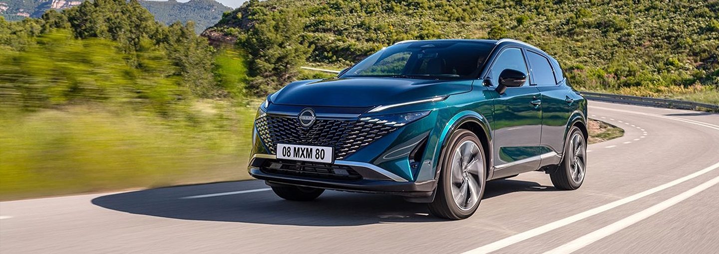 Nissan X-Trail prednji bočni pogled ispred kuće pri zalasku sunca.