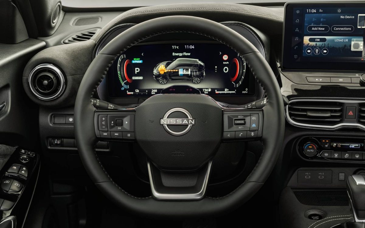 Blick auf das digitale Armaturenbrett und Lenkrad eines Nissan Juke mit Anzeige von Energiefluss, Geschwindigkeit und Parkmodus.