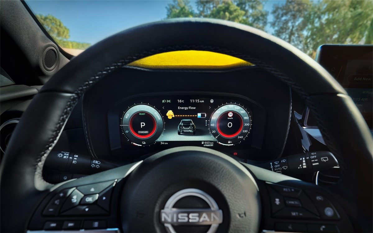 Blick auf das digitale Armaturenbrett und Lenkrad eines Nissan Juke mit Anzeige von Energiefluss, Geschwindigkeit und Parkmodus.