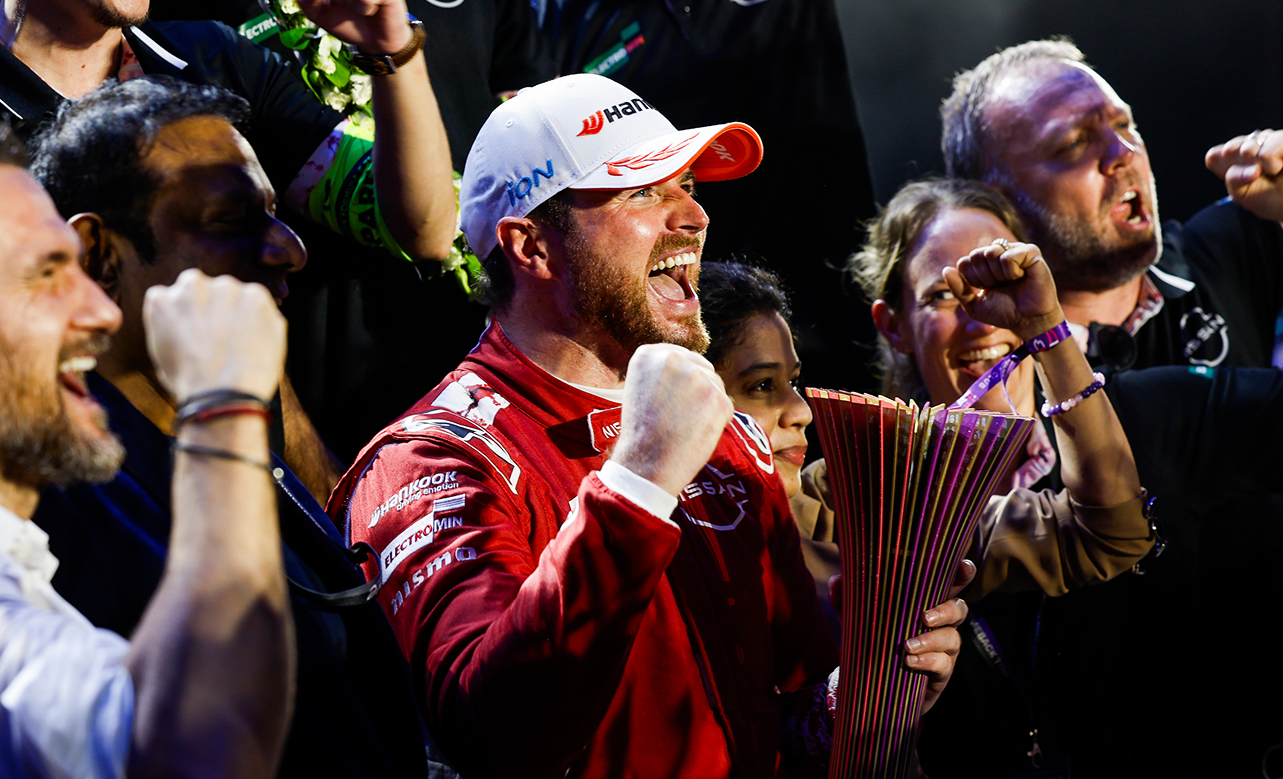 Oliver Rowland feiert seinen Sieg und hält die Trophäe in die Höhe