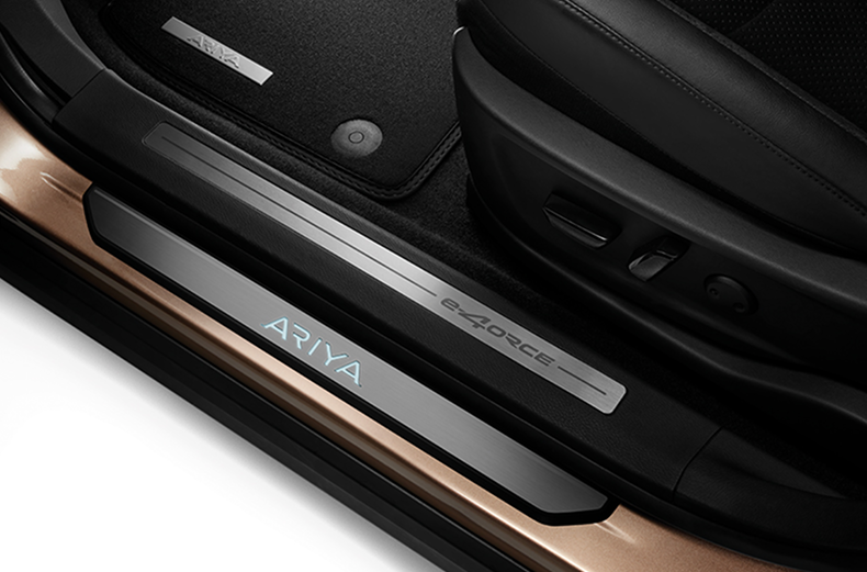 Schwarze beleuchtete Einstiegsleiste mit ARIYA Schriftzug an einem Nissan ARIYA montiert.