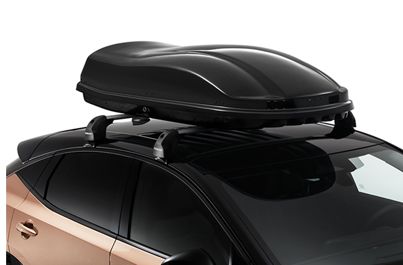 Schwarze Dachbox auf dem Dach eines Nissan ARIYA montiert.