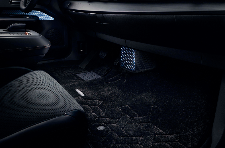 Gemusterte Teppich-Fußmatte in der gesamten ersten Reihe eines Nissan ARIYA ausgelegt.