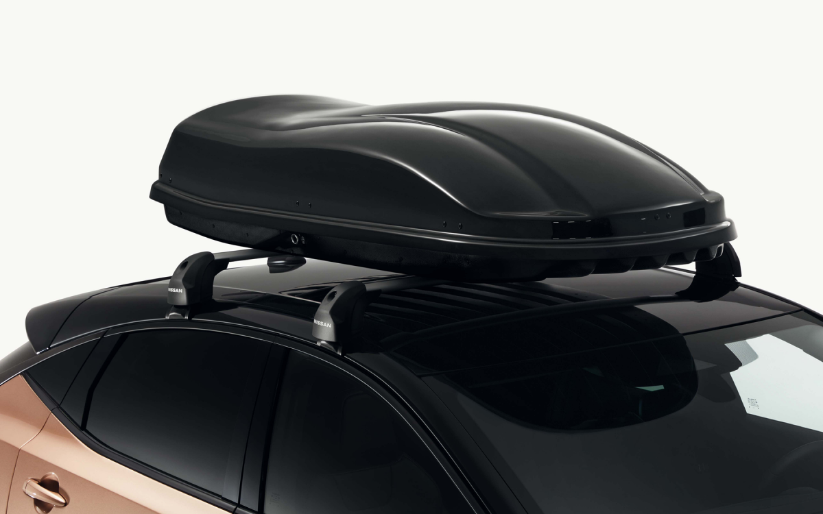 Schwarze Dachbox auf dem Dach eines Nissan ARIYA montiert.