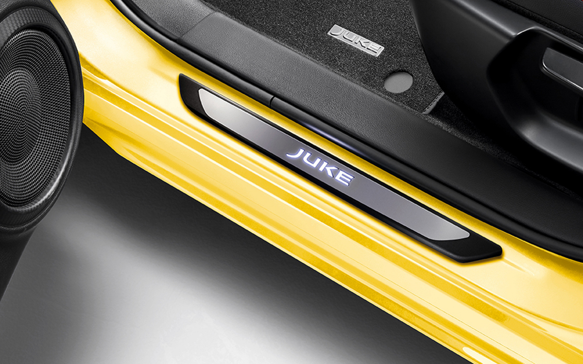 Beleuchtete Einstiegsleiste mit Juke Schriftzug an einem gelben Nissan Juke montiert.