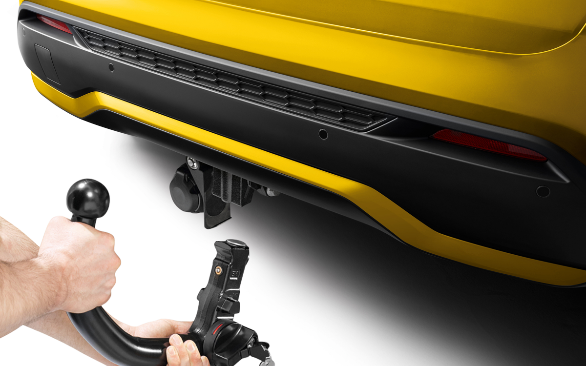 Abnehmbare Anhängerkupplung bei der Montage am Heck eines gelben Nissan Juke.