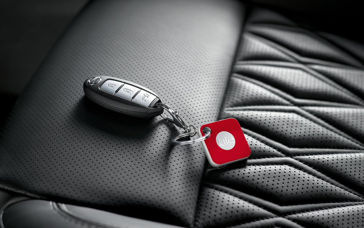 Roter Schlüsselfinder an einem schwarzen Nissan Autoschlüssel befestigt.