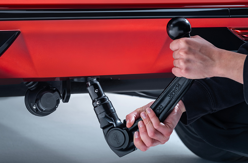 Abnehmbare Anhängerkupplung bei der Montage am Heck eines roten Nissan Qashqai.