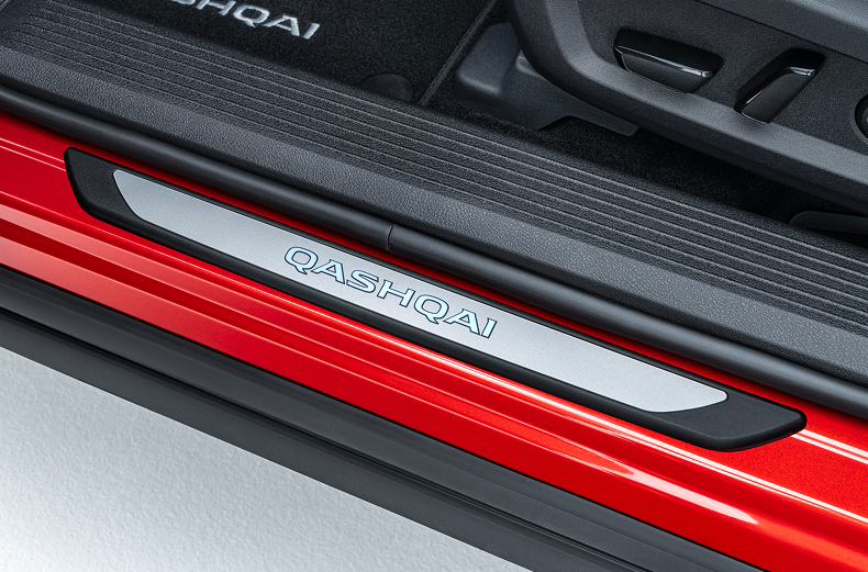 Silberne beleuchtete Einstiegsleiste mit Qashqai Schriftzug an einem roten Nissan Qashqai montiert.
