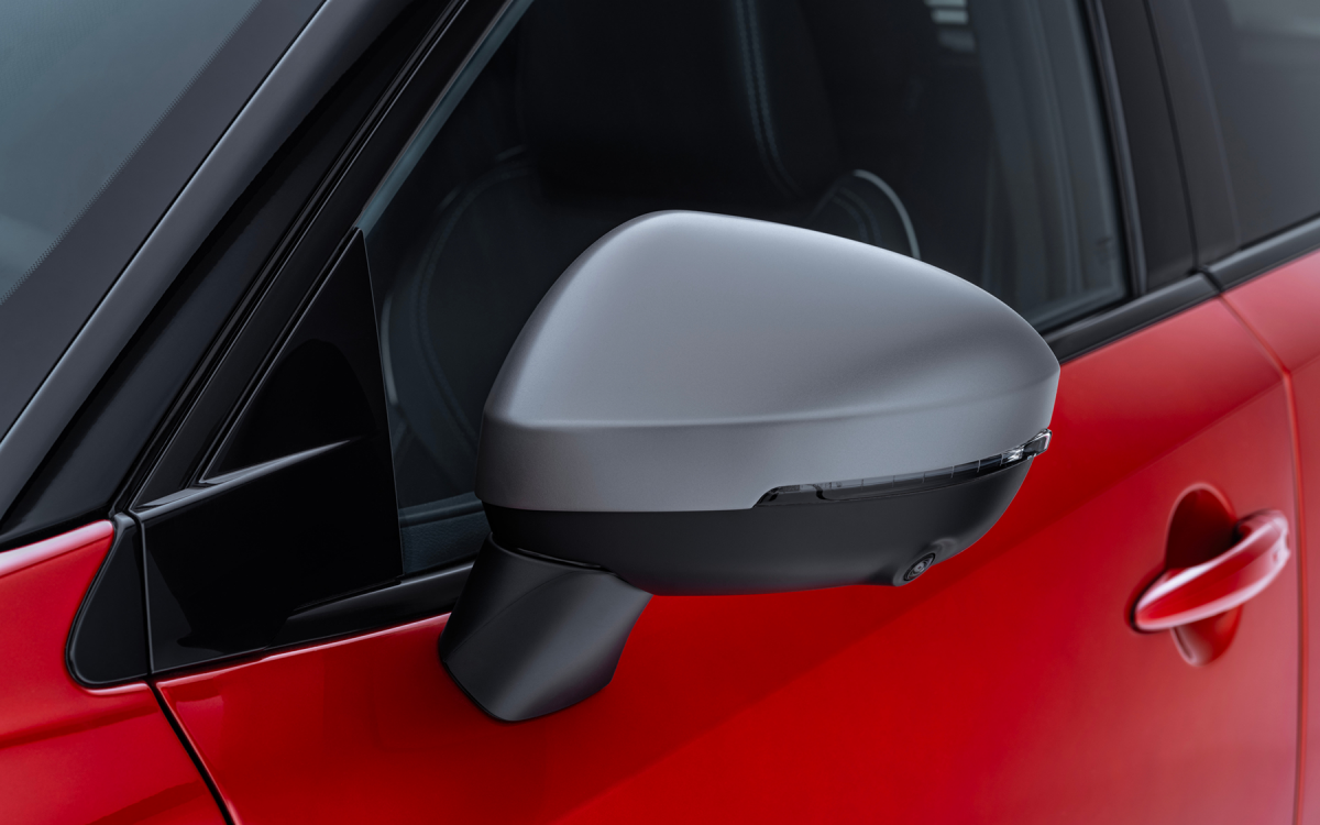 Graue Spiegelkappe montiert an einem roten Nissan Qashqai.