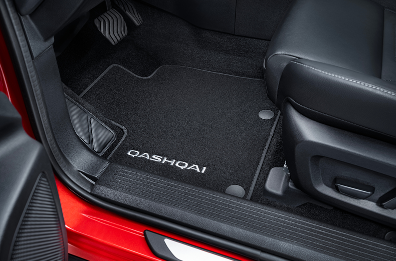 Velours-Fußmatte mit Qashqai Schriftzug auf der Fahrerseite in einem roten Nissan Qashqai.