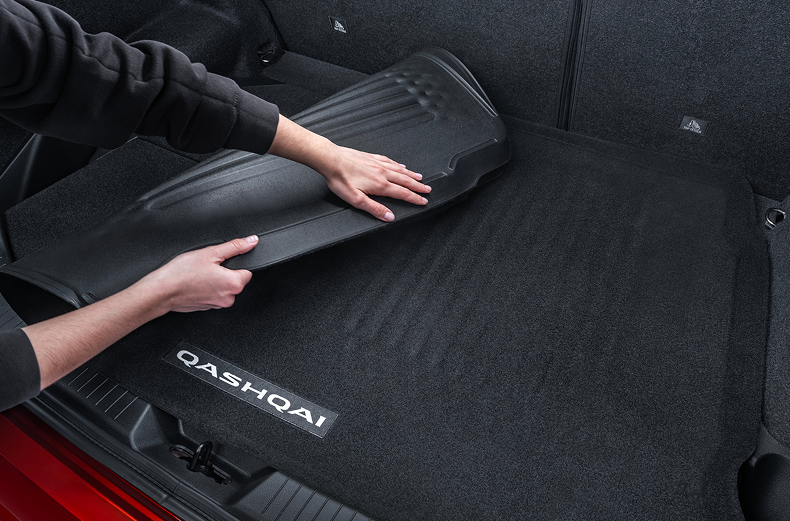 Wendbare Kofferraumwanne, die im Kofferraum eines roten Nissan Qashqai umgeschlagen wird – sowohl Gummiseite als auch Veloursseite sichtbar.