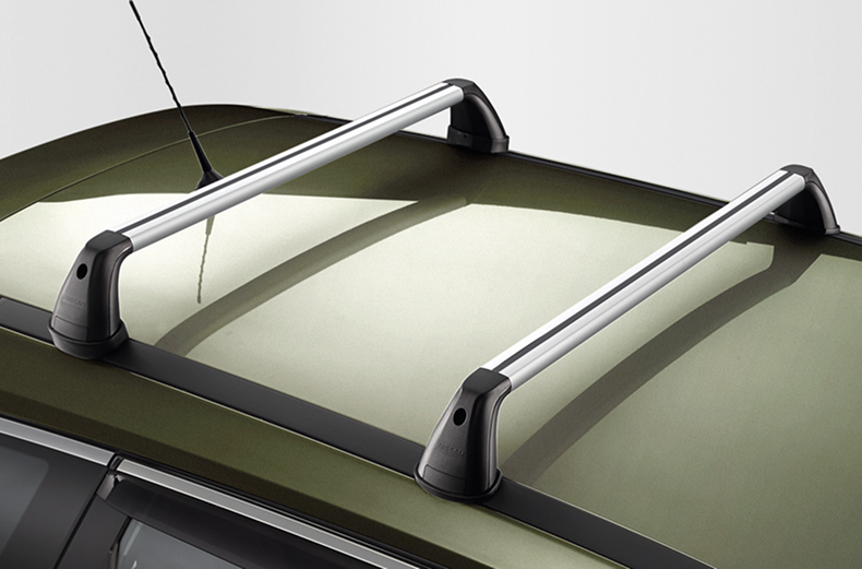 Silberne Querträger auf dem Dach eines grünen Nissan X-Trail montiert.