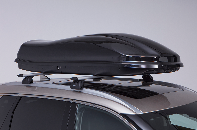 Schwarze Dachbox auf dem Dach eines Nissan X-Trail montiert.