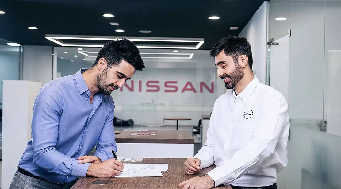 Cliente Nissan viendo la promesa de servicio al cliente de Nissan