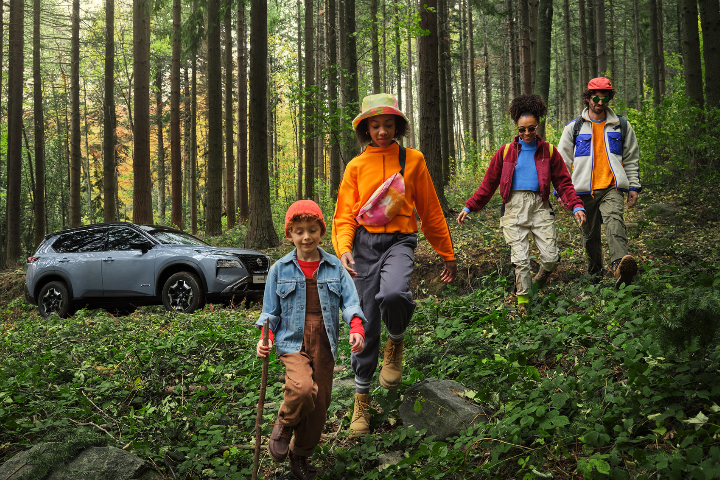 Compromiso sostenible Nissan, familia en un bosque con un Nissan X.Trail Adventure de fondo
