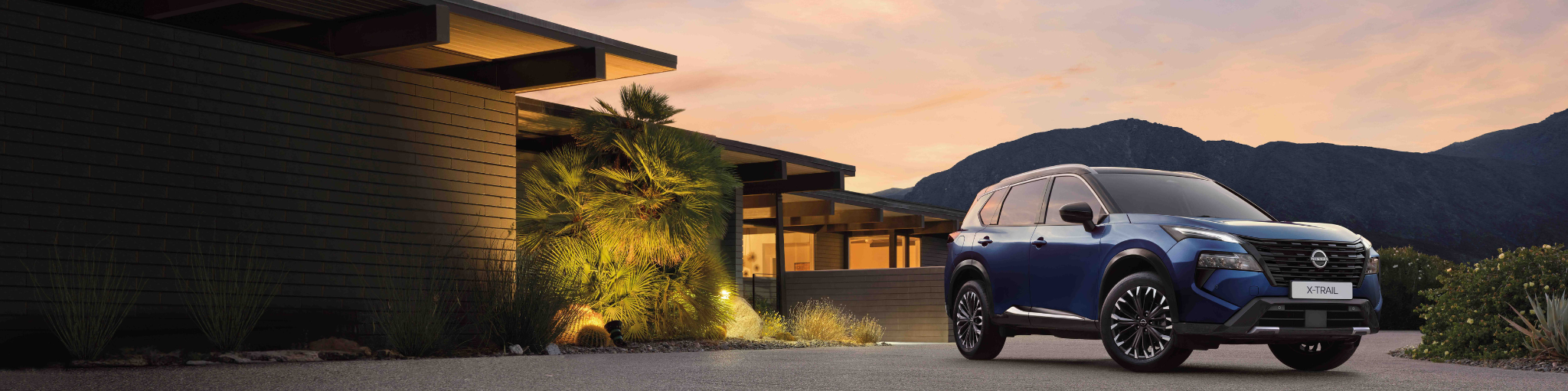 Nissan X-Trail SUV híbrido con casa y montañas de fondo
