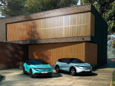 Nissan Ariya y Nissan Leaf con una casa de fondo