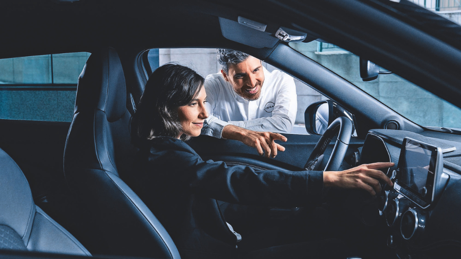Mujer dentro de su Nissan eléctrico tras pasar la inspección correctamente