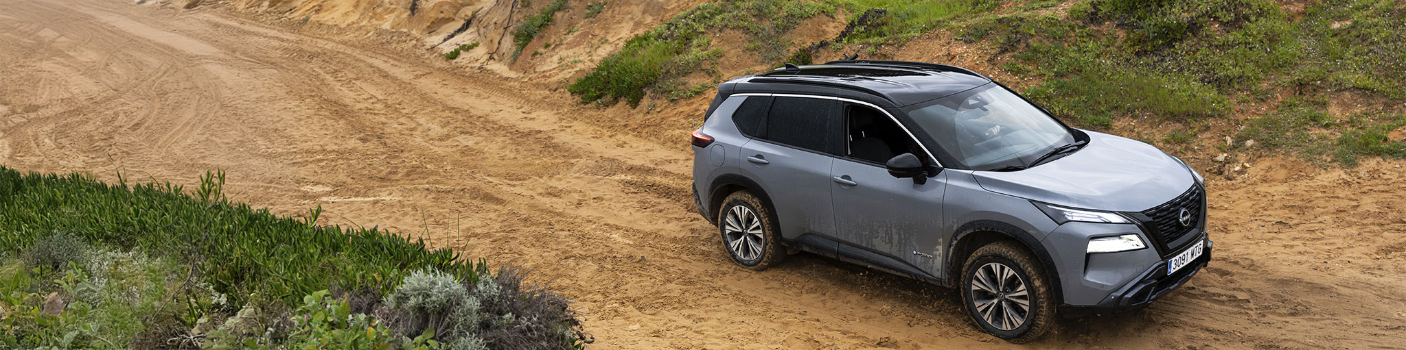 Un vehículo Nissan estacionado en un camino de tierra