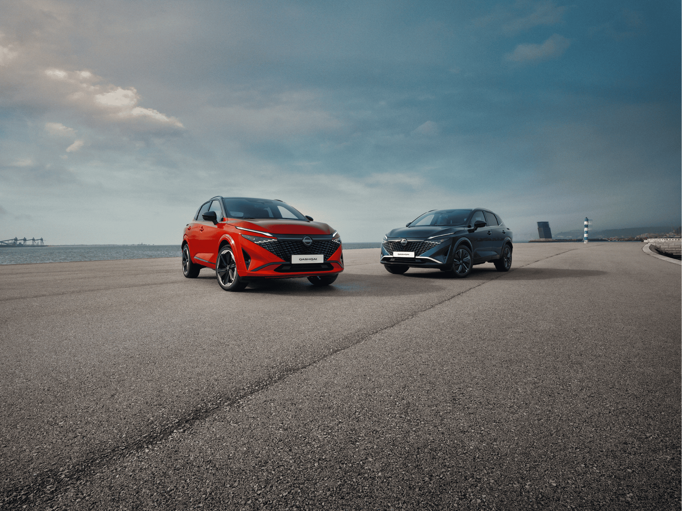 Nissan Qashqai rojo E-POWER y Nissan Qashqai azul junto al mar