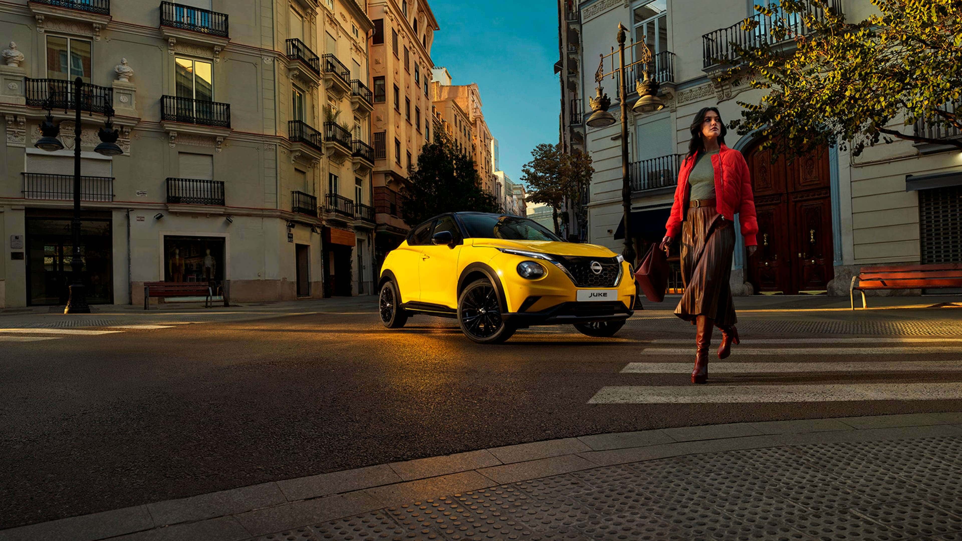 Mujer cruzando una calle junto a un Nissan Juke amarillo