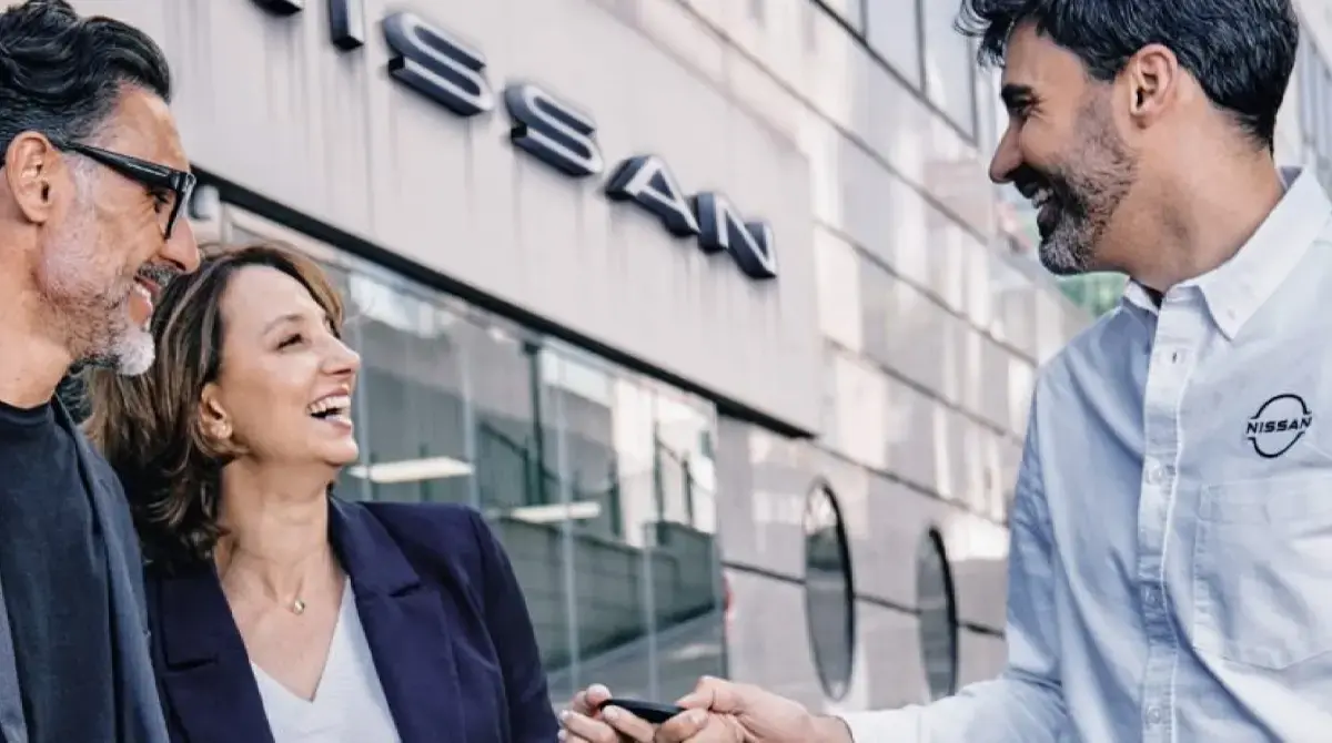 Una pareja junto a un vendedor de Nissan