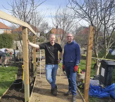 Dos hombres con un jardín de fondo