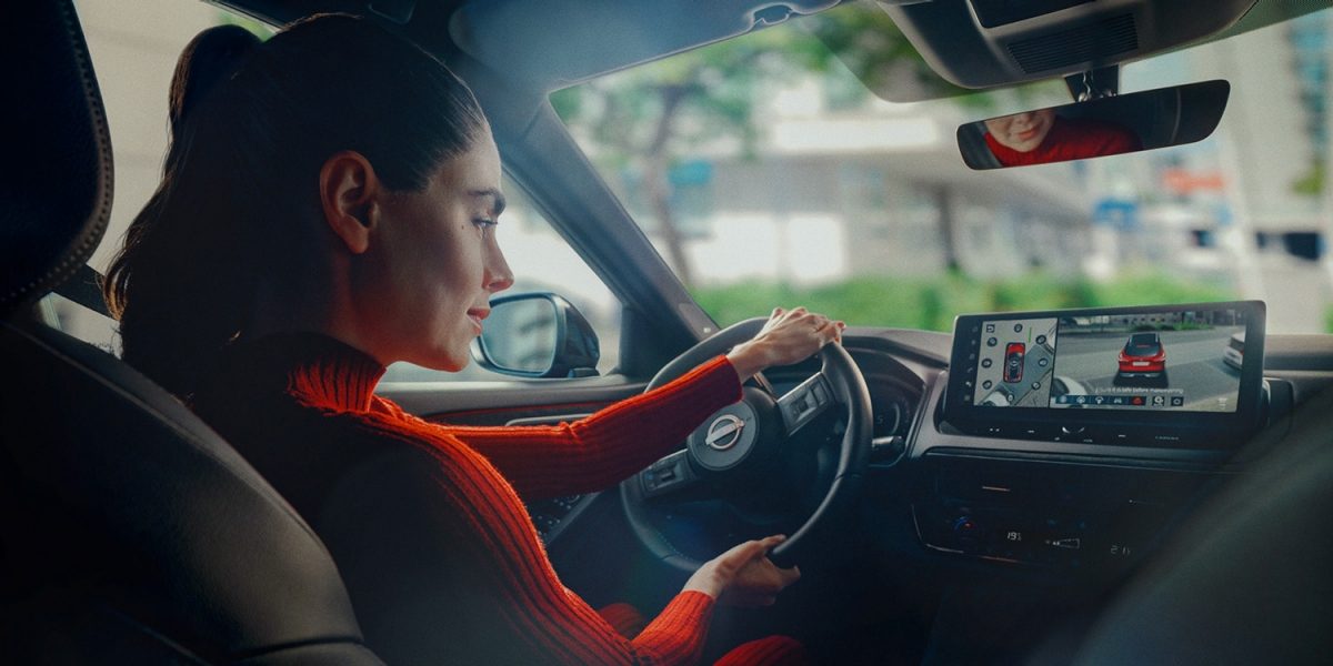 Mujer aparcando un Nissan Qashqai rojo