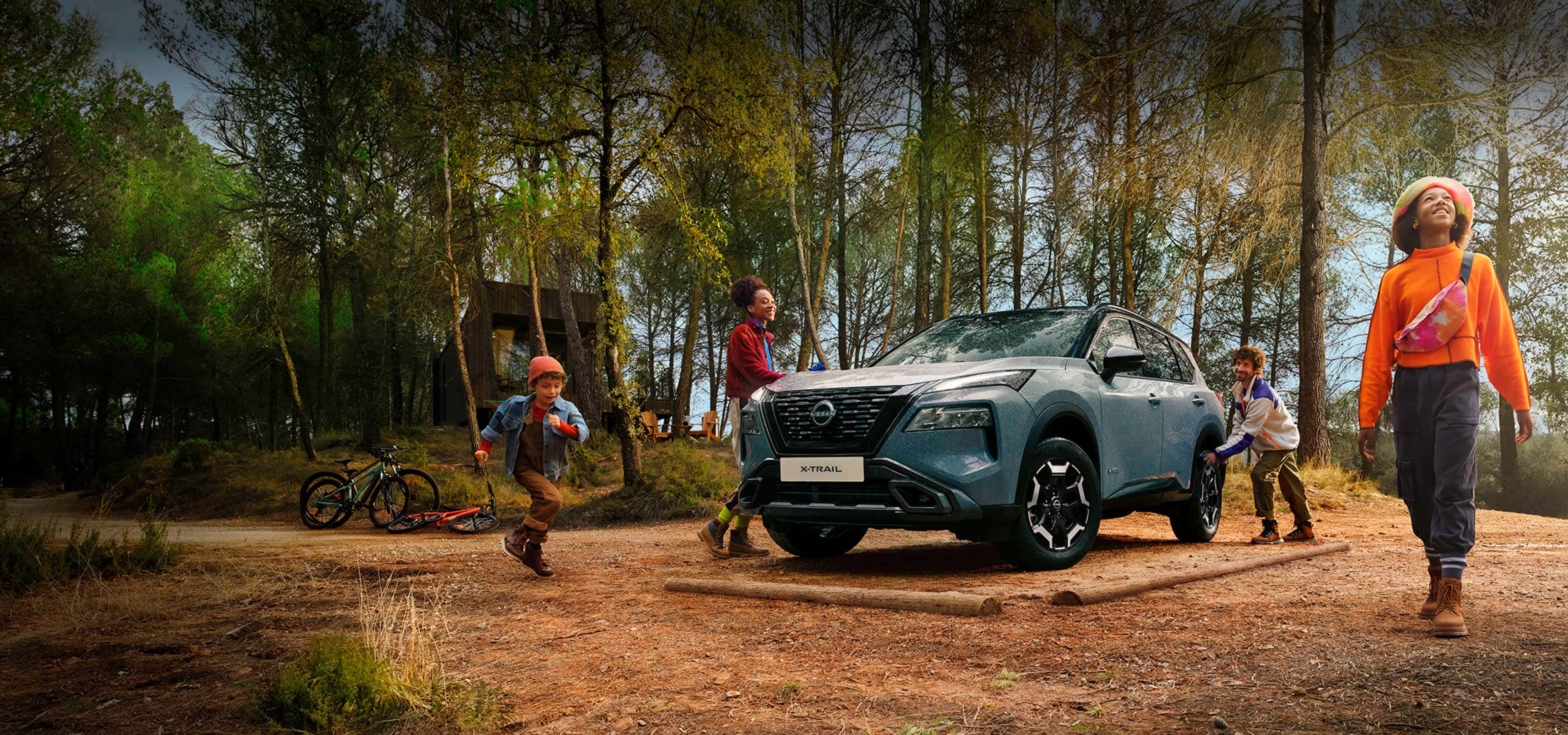 Vista frontal 3/4 del Nissan X-TRAIL ADVENTURE SUV con familia 